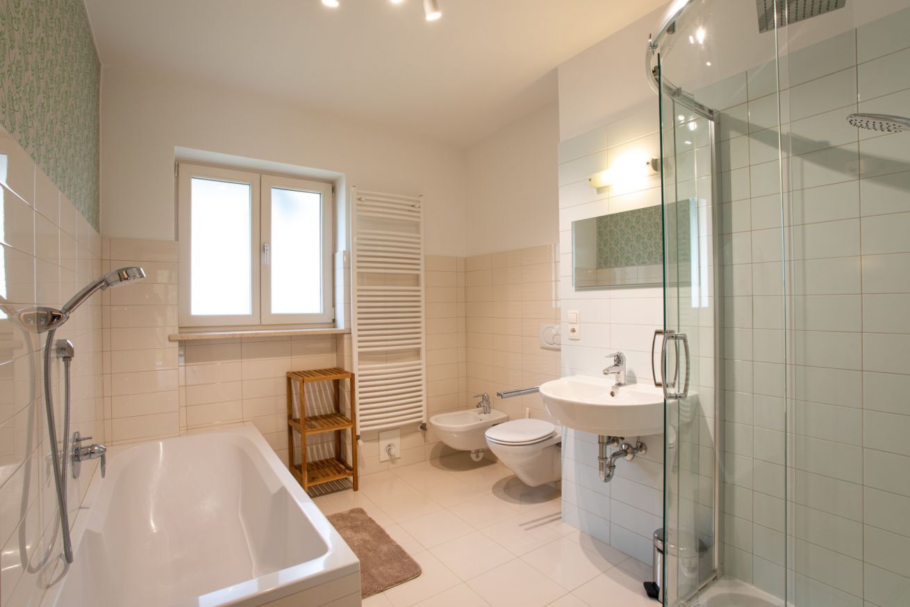 Un bagno moderno con vasca, doccia in vetro e lavabo.