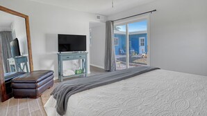 Ein Schlafzimmer mit Bett, Fernseher, Schreibtisch und einem Balkon mit Blick.