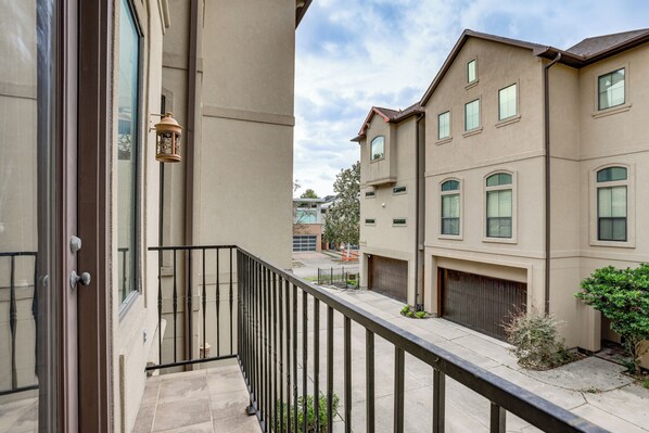 A residential building with a balcony, a door, and a window. - Walkable + Group-friendly: Houston Home By Stadium (Houston)