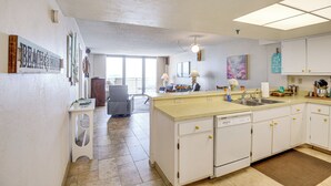 A kitchen with white cabinets, a dishwasher, and a sink. There is a window providing natural light and a view of the outdoors. - Steps to Shore, Pool Access: New Smyrna Beach Gem! (New Smyrna Beach)