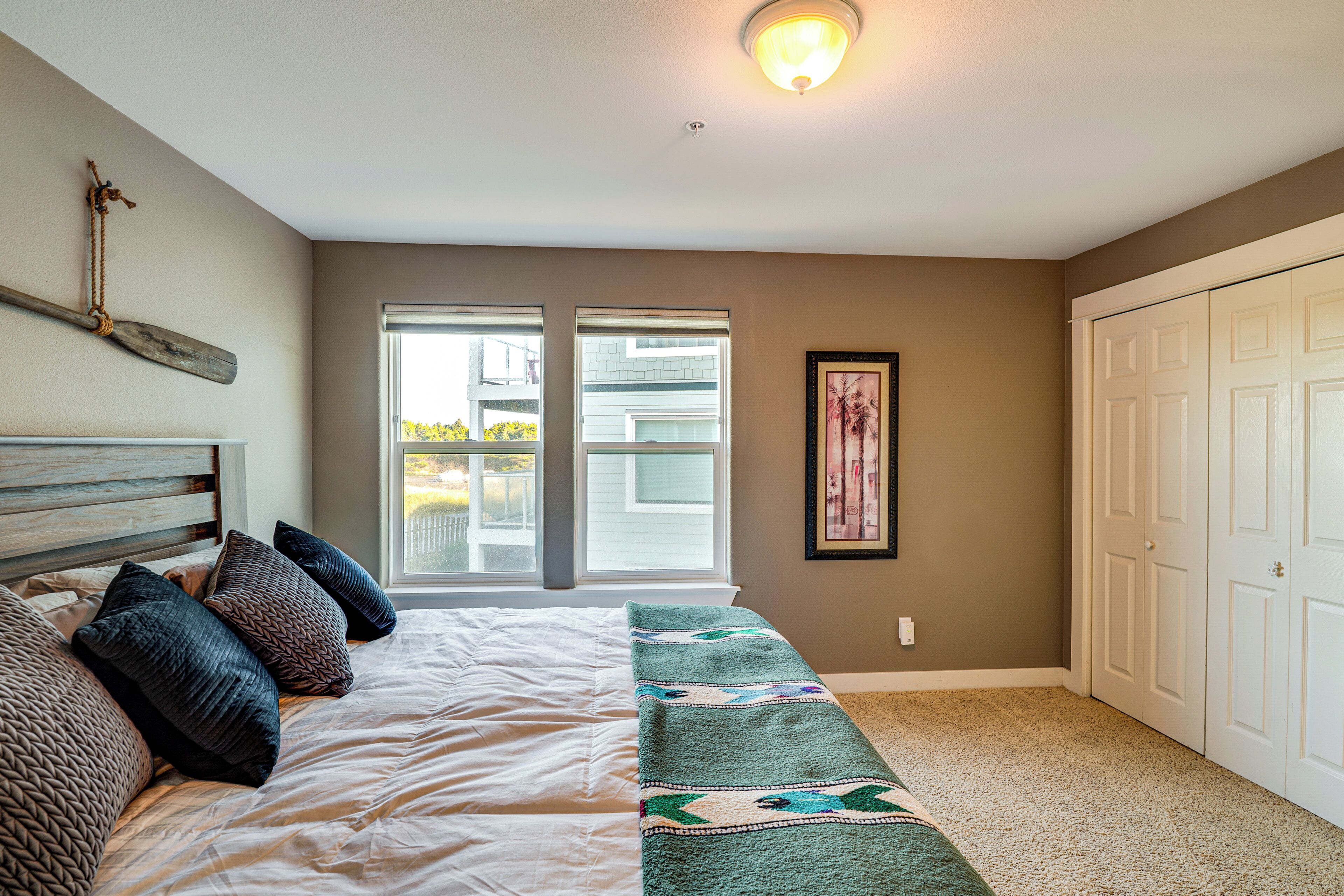 Un dormitorio con cama, ventana, puerta y lámpara.