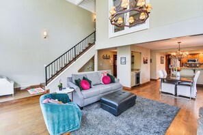 A spacious living area with a grey sofa, teal armchair, and a black ottoman. A staircase leads to an upper level, and a chandelier hangs above the dining area. - 3 Mi to Vail Ski Resort! Mtn-view Haven w/ 2 Decks (Vail)