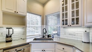 A kitchen with white cabinets, a dishwasher, a sink, and a window with blinds. - 3 Mi to Dtwn Salem: Cozy Gem w/ Sunroom! (Salem)