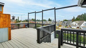 A wooden deck with a black railing, overlooking a residential area with houses and trees. - 3 Mi to Dtwn Salem: Cozy Gem w/ Sunroom! (Salem)