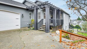A residential house with a garage, a covered porch, and a staircase leading to the front door. - 3 Mi to Dtwn Salem: Cozy Gem w/ Sunroom! (Salem)