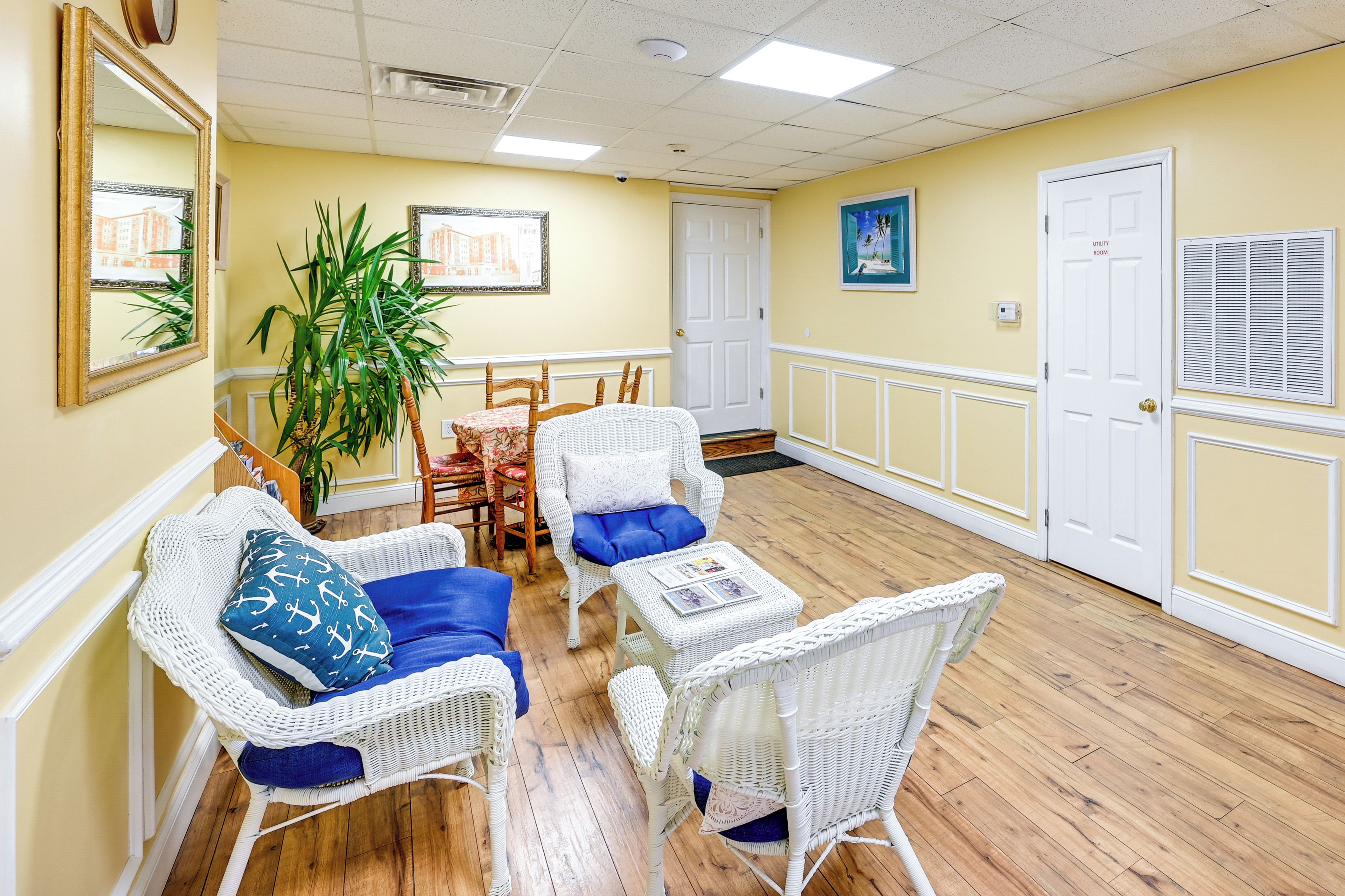 A room with wicker furniture, a wooden floor, and a door labeled "utility room".
