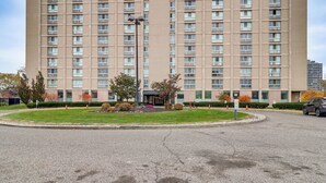 A high-rise hotel with multiple floors, a landscaped courtyard, and a parking area. - 2 Mi to DMC & Children's Hospital: Modern Studio (Detroit)