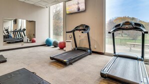 A gym with treadmills, exercise balls, and a large mirror. - 2 Mi to DMC & Children's Hospital: Modern Studio (Detroit)
