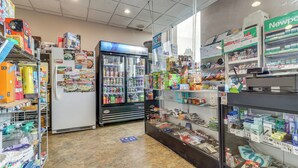 A grocery store interior with refrigerated sections, shelves stocked with various products, and a checkout area. - 2 Mi to DMC & Children's Hospital: Modern Studio (Detroit)