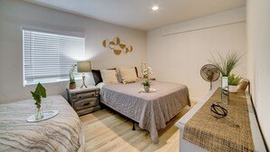 A bedroom with a bed, bedside table, lamp, and a potted plant. - 10 Mi to Riverside! Apt Near Ruhs Medical Center (Moreno Valley)