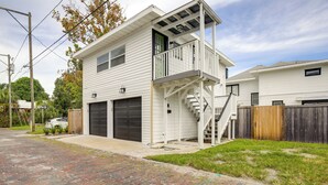 Une maison à deux étages avec un porche à l’avant, un escalier menant à l’étage supérieur et un garage.