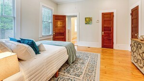 Une chambre à coucher avec un lit, une commode et une fenêtre.