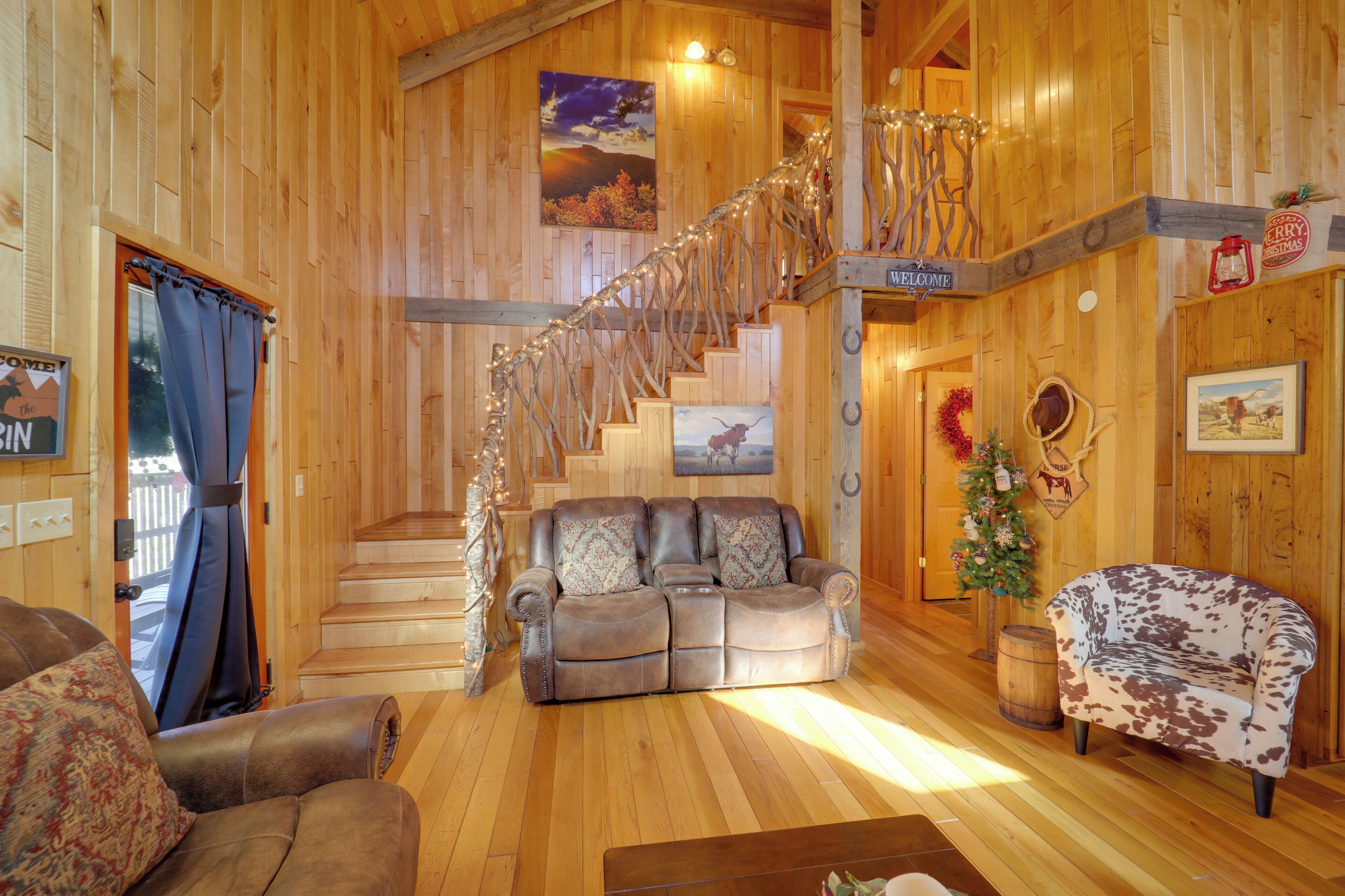 Un interior de madera con un sofá, un sillón estampado, una escalera y un adorno navideño.