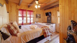 A wooden cabin bedroom with a bed, a desk, a television, and a bear decoration. - < 1 Mi to Linville Falls: Family Gem w/ Game Room! (Marion)