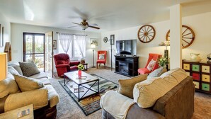 Una sala de estar con sofá, sillones, una mesa de centro, chimenea y televisor.