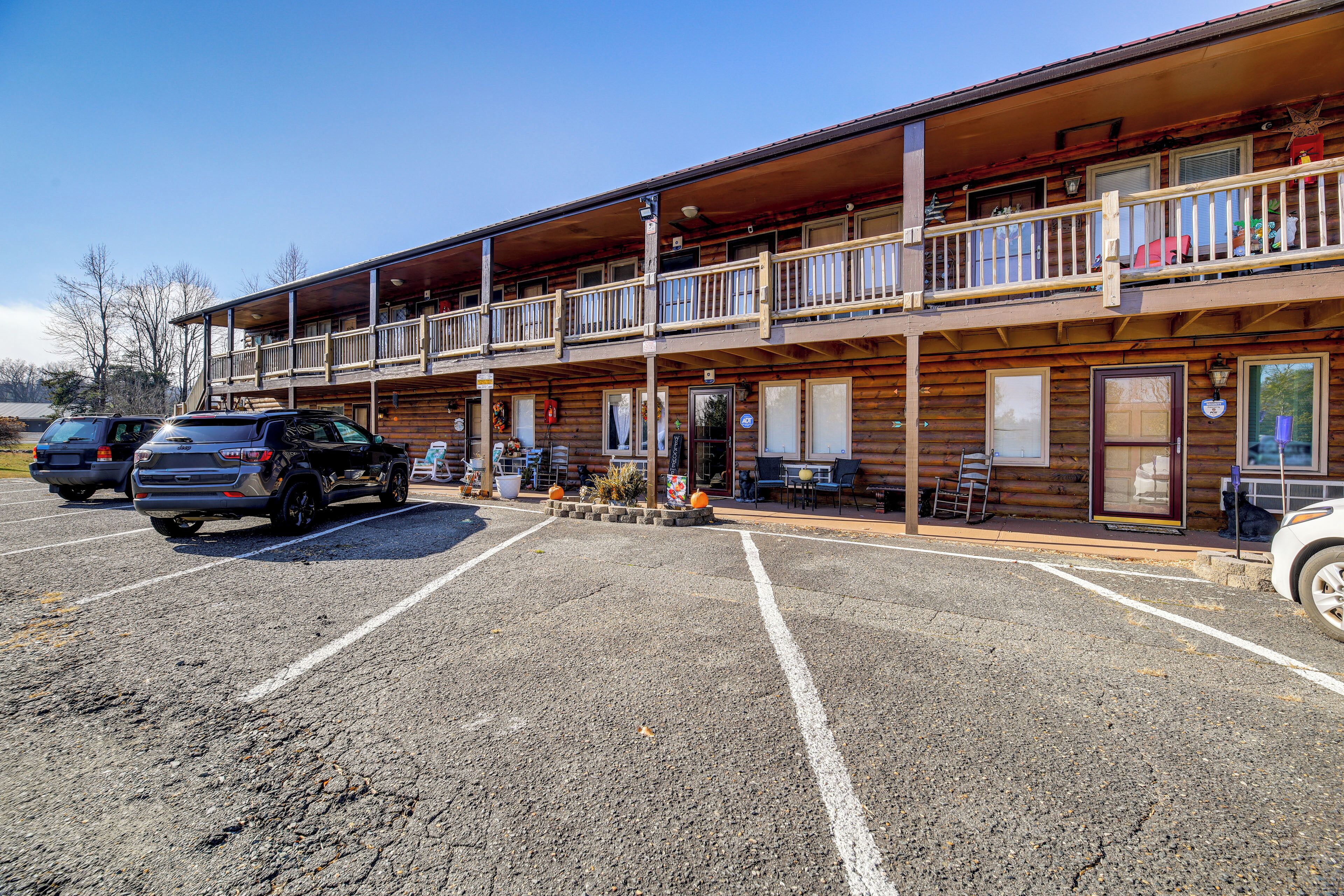 A two-story wooden building with a balcony, a parking lot, and a sign indicating a restaurant.