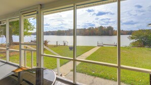 A covered outdoor area with large windows overlooking a lake and grassy area. - Lakefront Getaway w/ Dock & Views in Macon! (Macon)