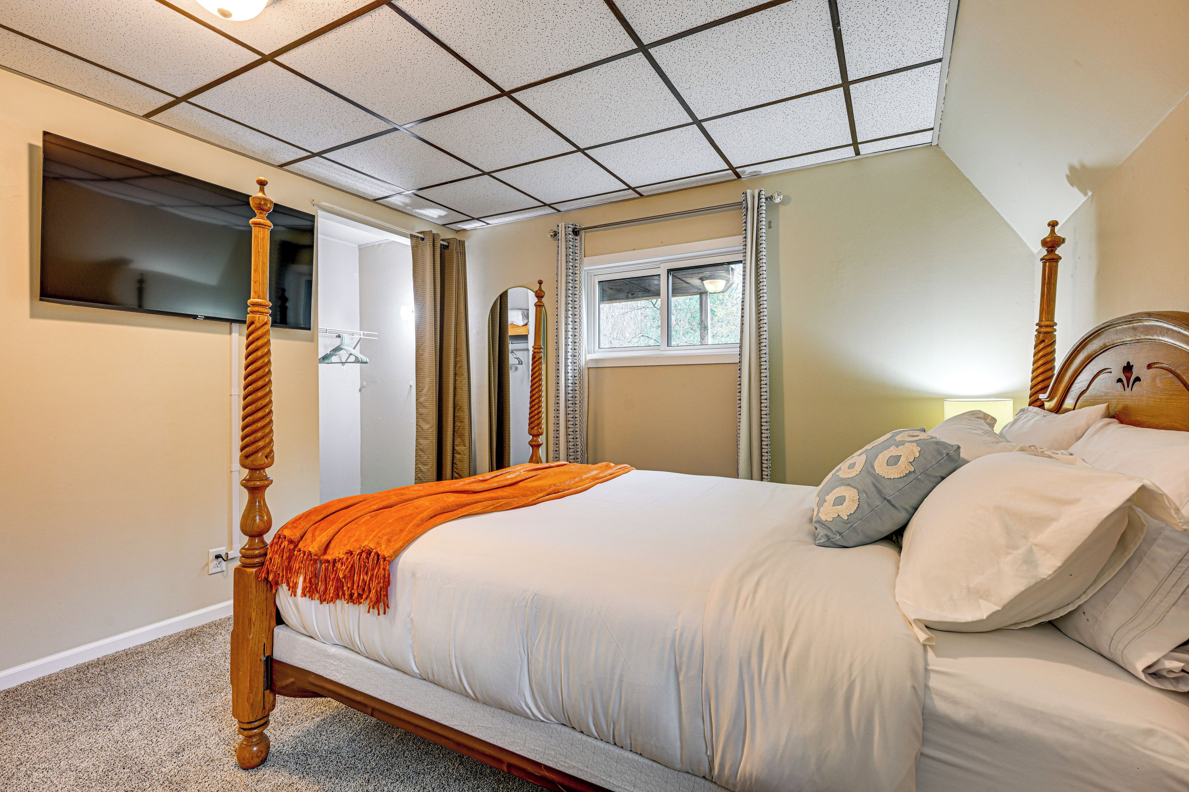Un dormitorio con cama con dosel, una ventana y un espejo.