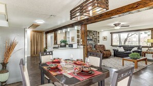 A dining area with a wooden table set for four, surrounded by chairs. - Deck & Yard: Wolf Creek Waterfront Home in Grove! (Grove)
