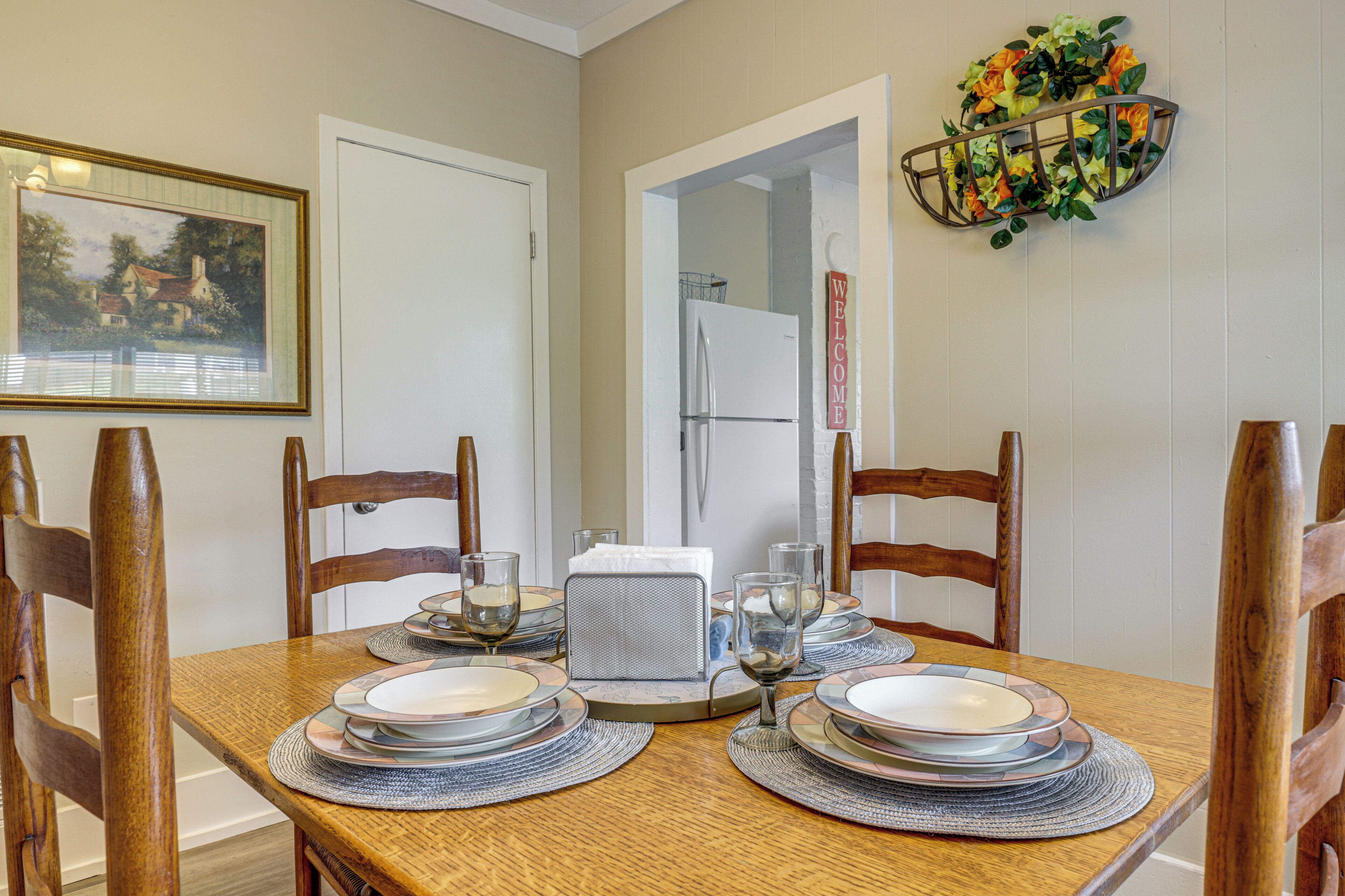 A dining table set with plates, glasses, and a centerpiece.