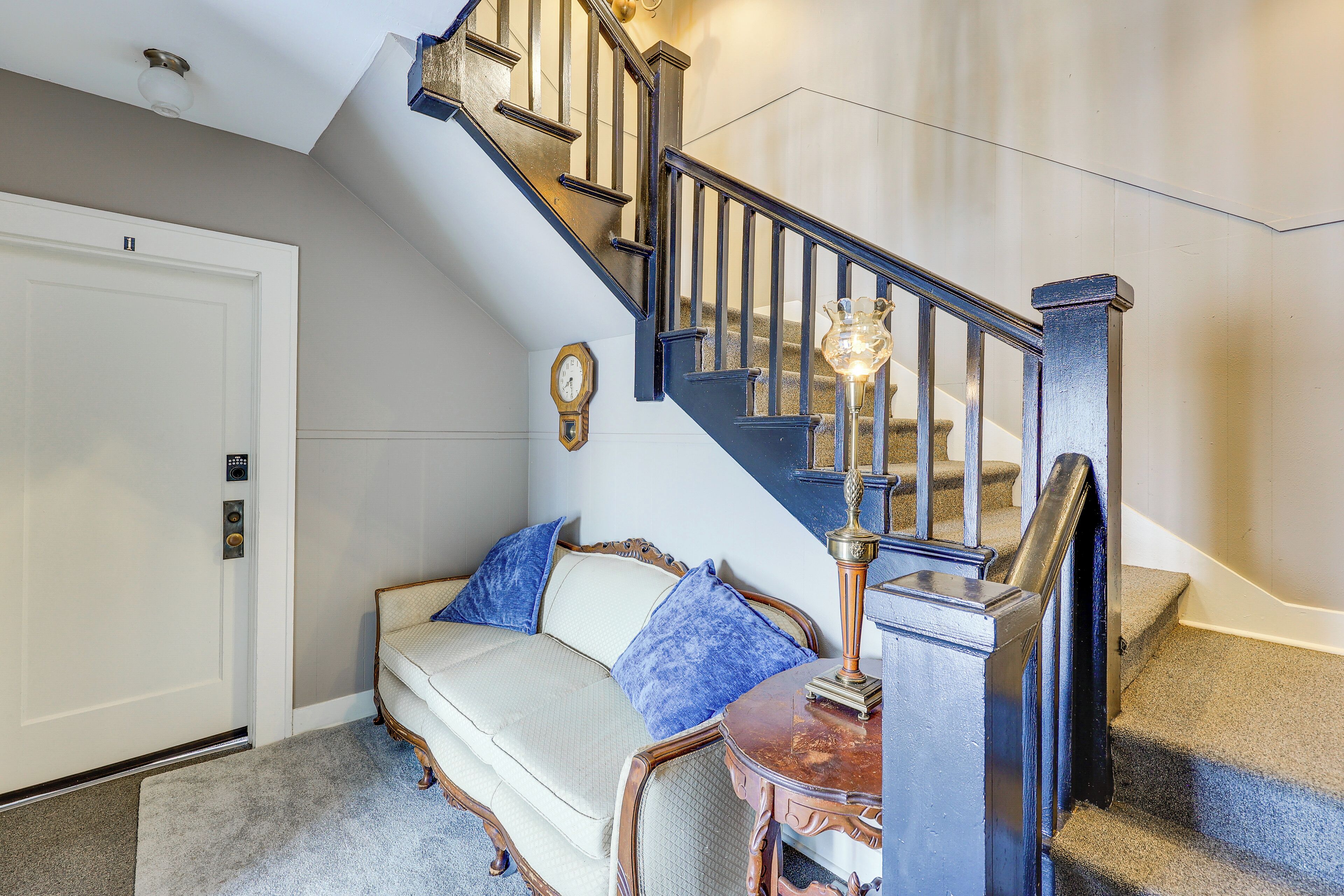 A staircase with a wooden handrail and a wall-mounted light fixture.
