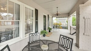 A covered patio with a round table and chairs, potted plants, and a chandelier. - < 1 Mi to Historic Dtwn Texarkana: Charming Home! (Texarkana)