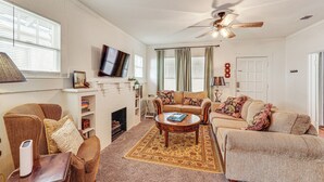 A living room with a fireplace, two sofas, a coffee table, and a ceiling fan. - < 1 Mi to Historic Dtwn Texarkana: Charming Home! (Texarkana)