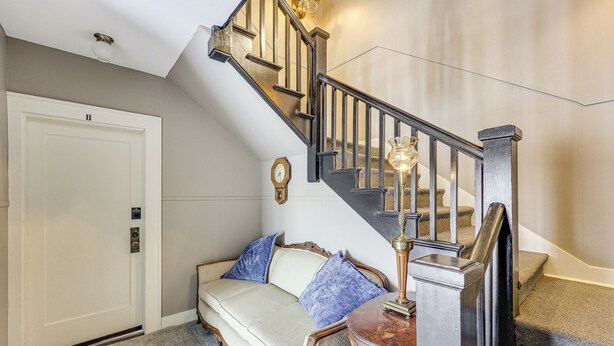 Un escalier avec une rampe en bois et un luminaire au sommet.