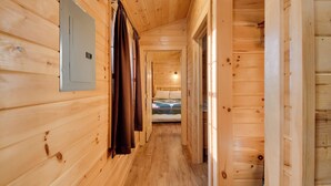 A wooden hallway with a bed at the end. - Shared Dock Access at Lakeside Sodus Bay Cabin! (North Rose)