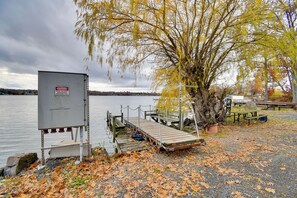 A dock extending into a lake with a warning sign, a picnic table, and a tree with yellow leaves. - Lake Access & Incredible Views at Sodus Bay Home! (North Rose)