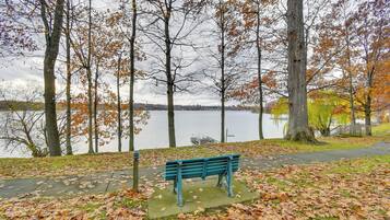 A park with a bench, trees, and a lake.