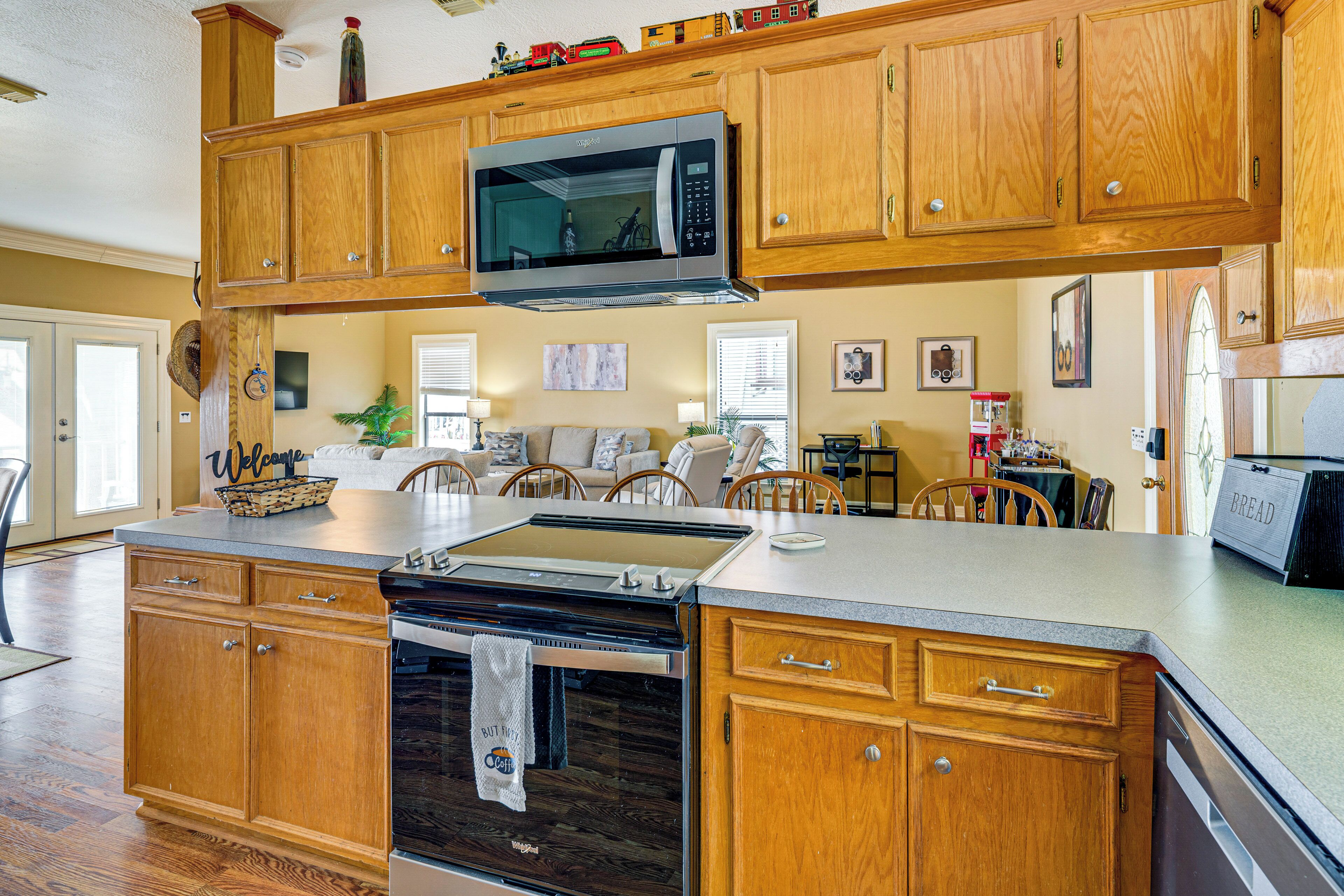 A kitchen with wooden cabinets, a stainless steel microwave, and a built-in oven.