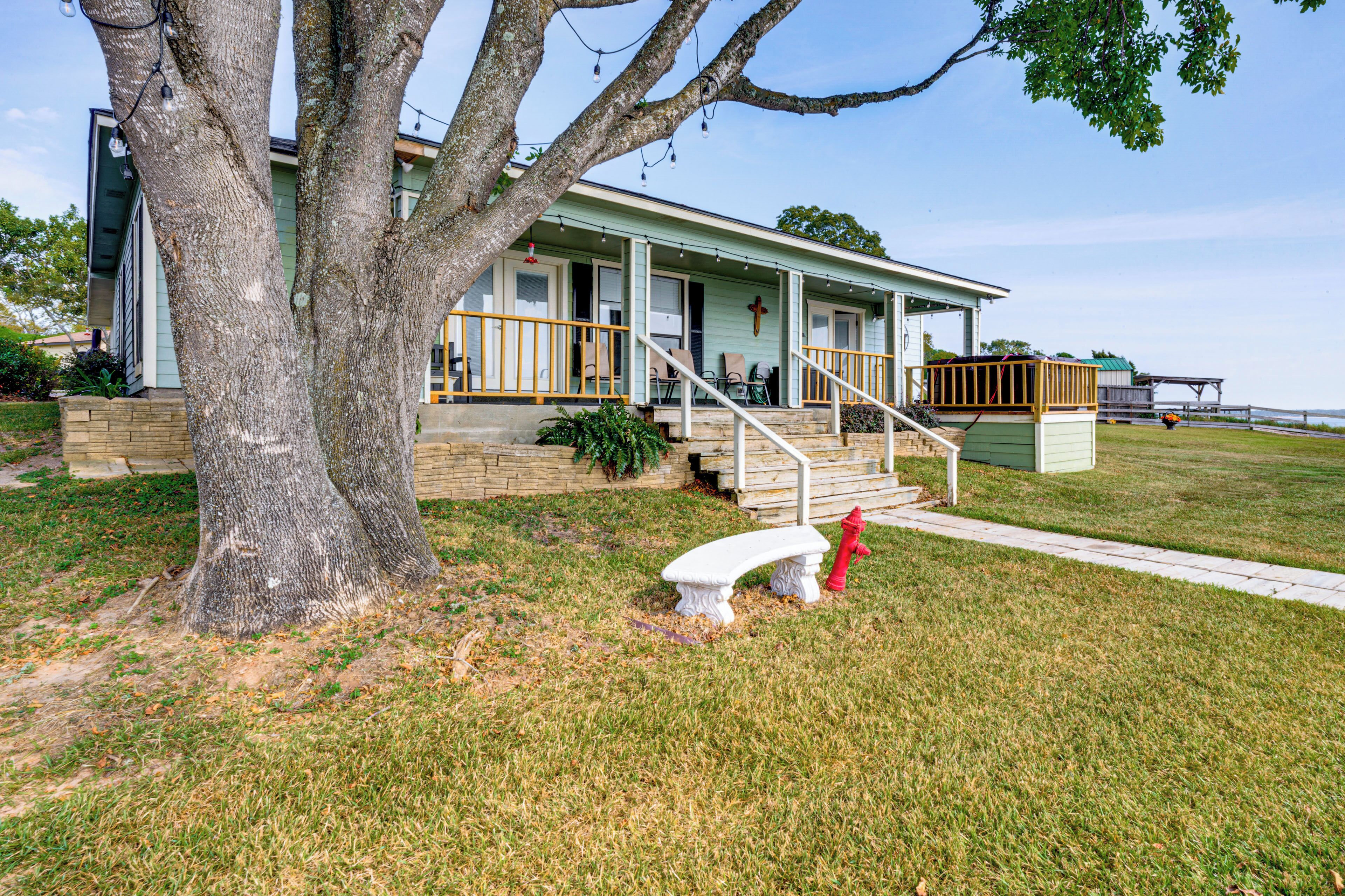 A house with a porch, steps, and a bench.