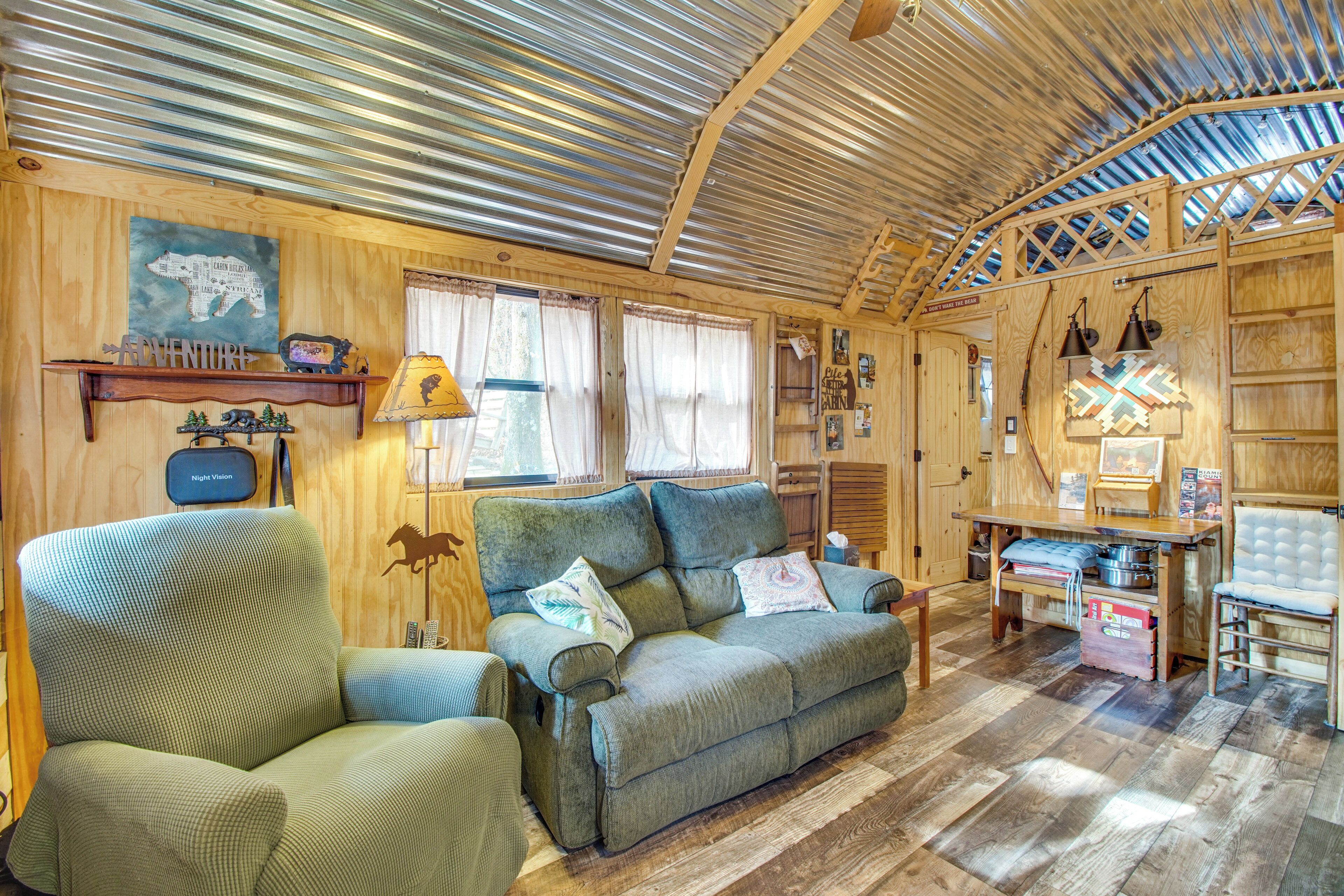 Een gezellig chaletinterieur met houten inrichting, een bank, een stoel en een eettafel.