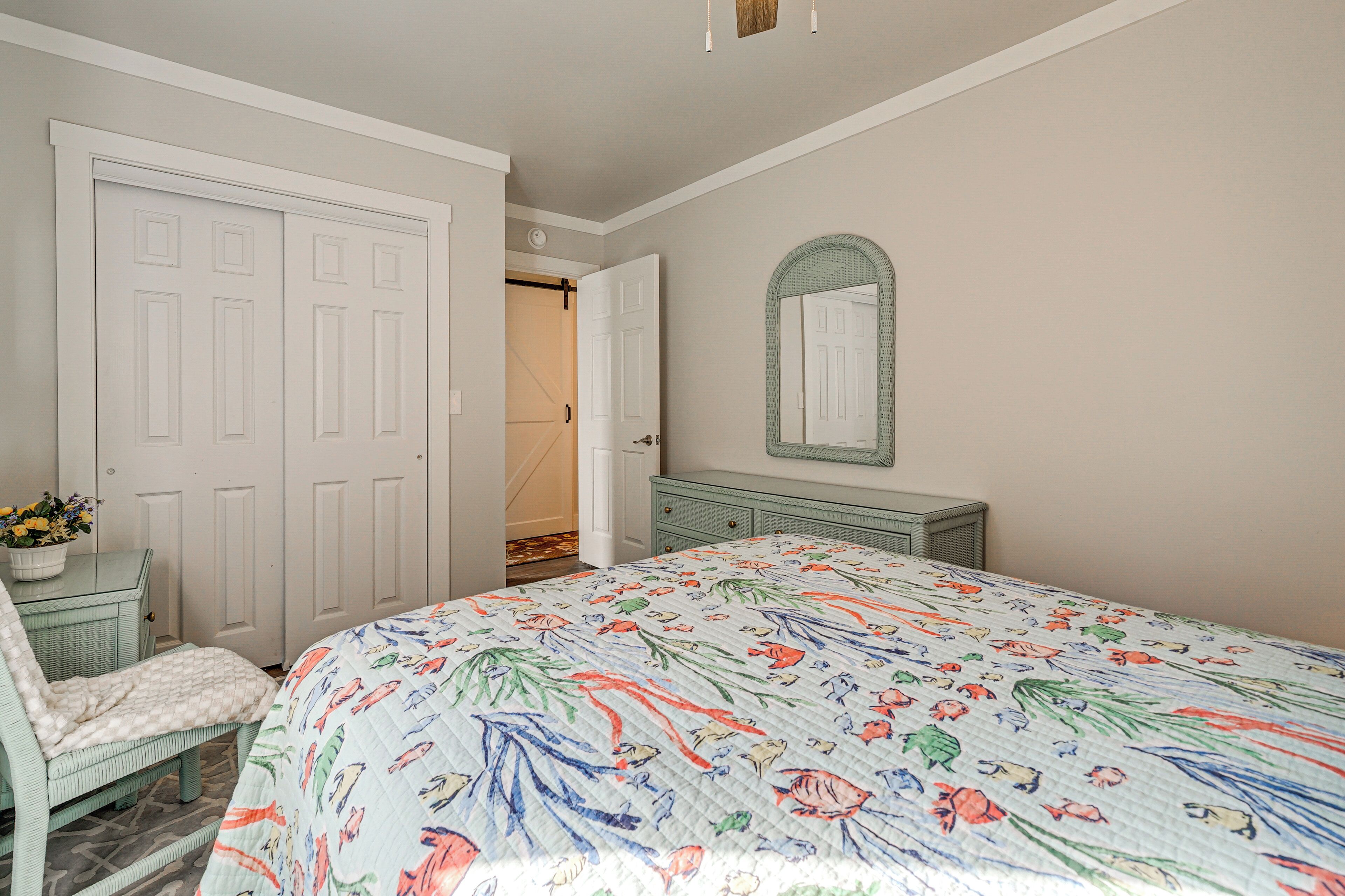 Un dormitorio con cama, cómoda, silla y puerta.
