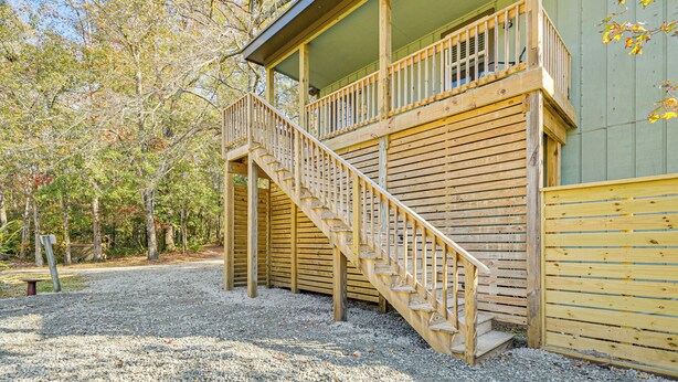 A wooden cabin with a balcony and a staircase leading to the upper floor. - Wooded Couples Haven! 15 Mi to Wrightsville Beach (Wilmington)