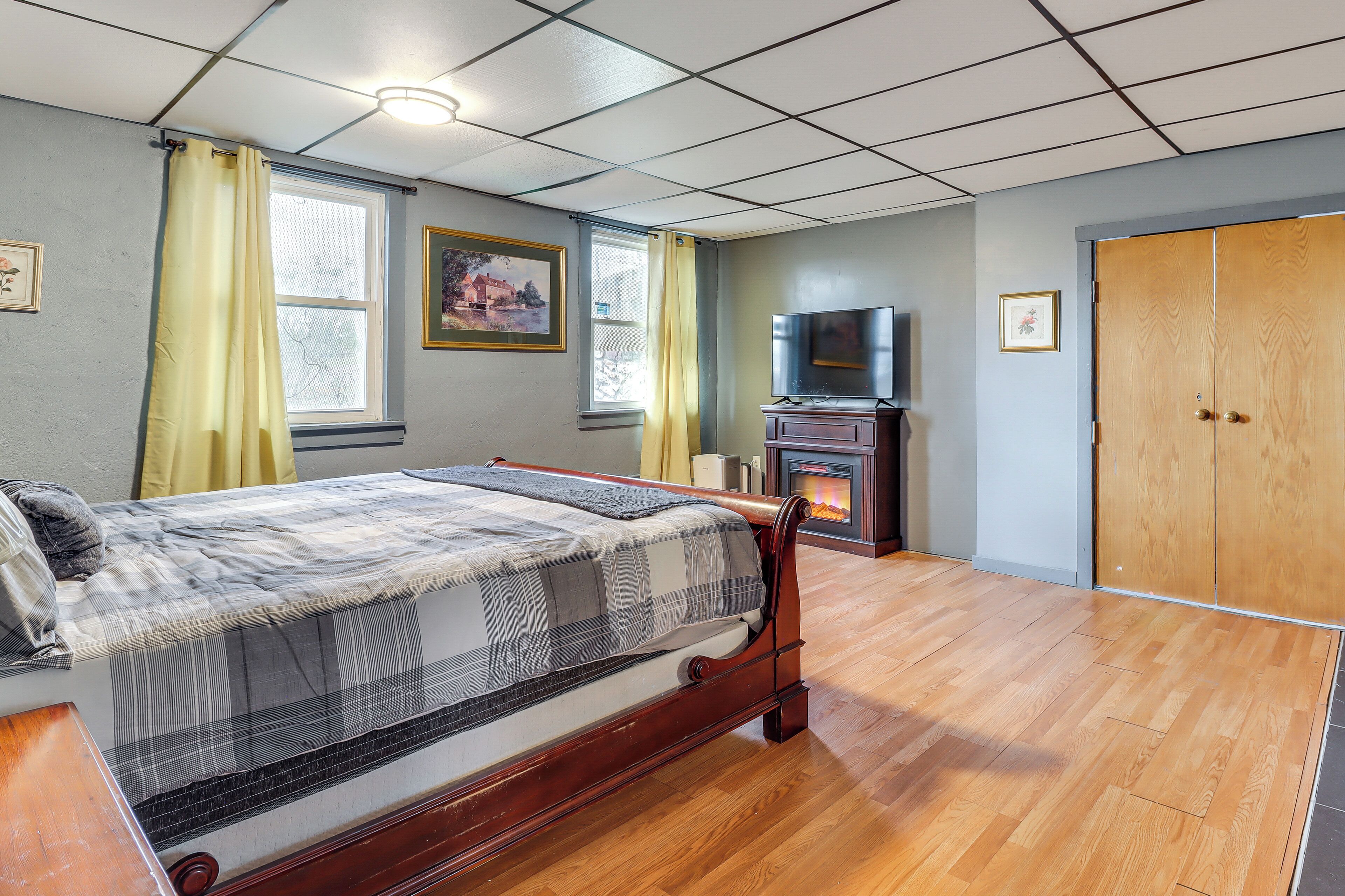 A bedroom with a bed, a television, a fireplace, and a wardrobe.
