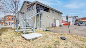 Ein zweistöckiges Gebäude mit Balkon, Treppe und Parkschild.
