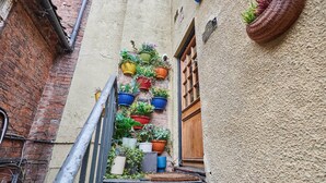 Una stretta scala con ringhiera in metallo che conduce a una porta in legno.