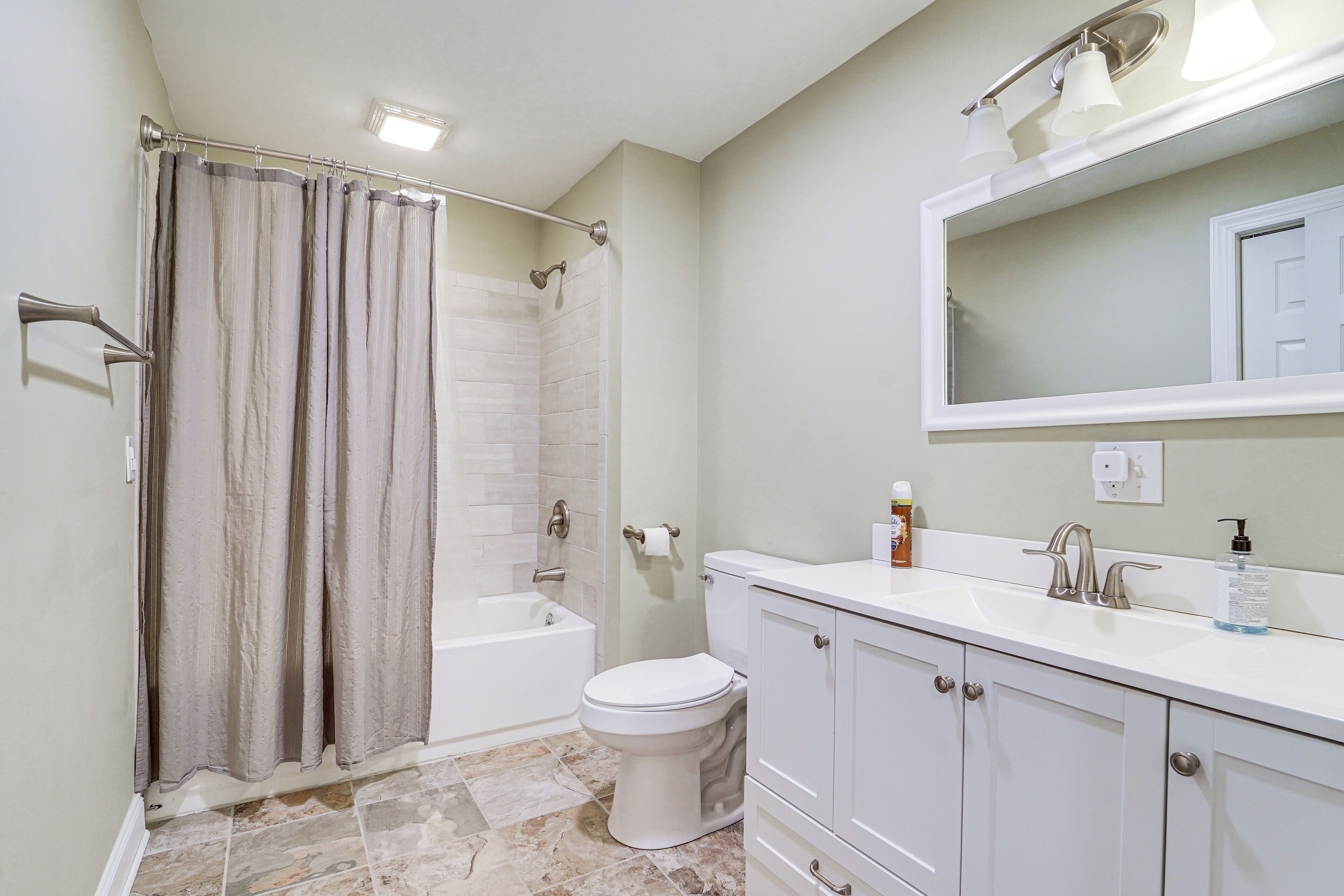A bathroom with a bathtub, toilet, and sink.