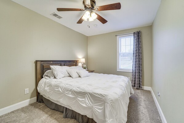 A bedroom with a bed, a ceiling fan, a window with curtains, and a carpeted floor. - Mtn Views! Peaceful Rural Retreat in Mapleton (Mapleton Depot)