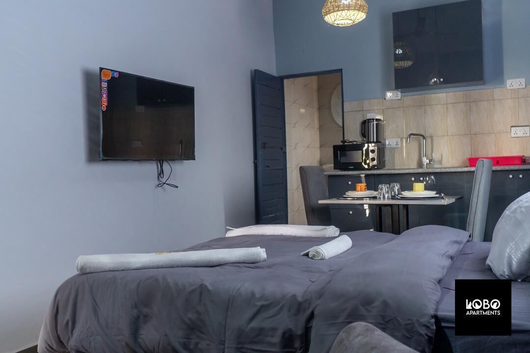 Estudio, vista a la ciudad | Espacio para trabajar con laptop y tabla de planchar con plancha 