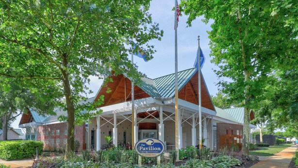 Un bâtiment doté d’un porche couvert, d’une enseigne indiquant « The Pavilion » et d’un mât sur lequel flotte un drapeau américain.