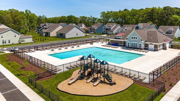 Una zona residenziale con piscina, area giochi e case.