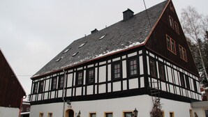 A traditional half-timbered building with a steeply pitched roof and dormer windows. - Vacation in a half-timbered house, experience a real piece of living history. (Sehmatal-Neudorf)