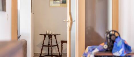 Une pièce comprenant une machine à coudre, une petite table ornée d’objets décoratifs et un tableau encadré accroché au mur.