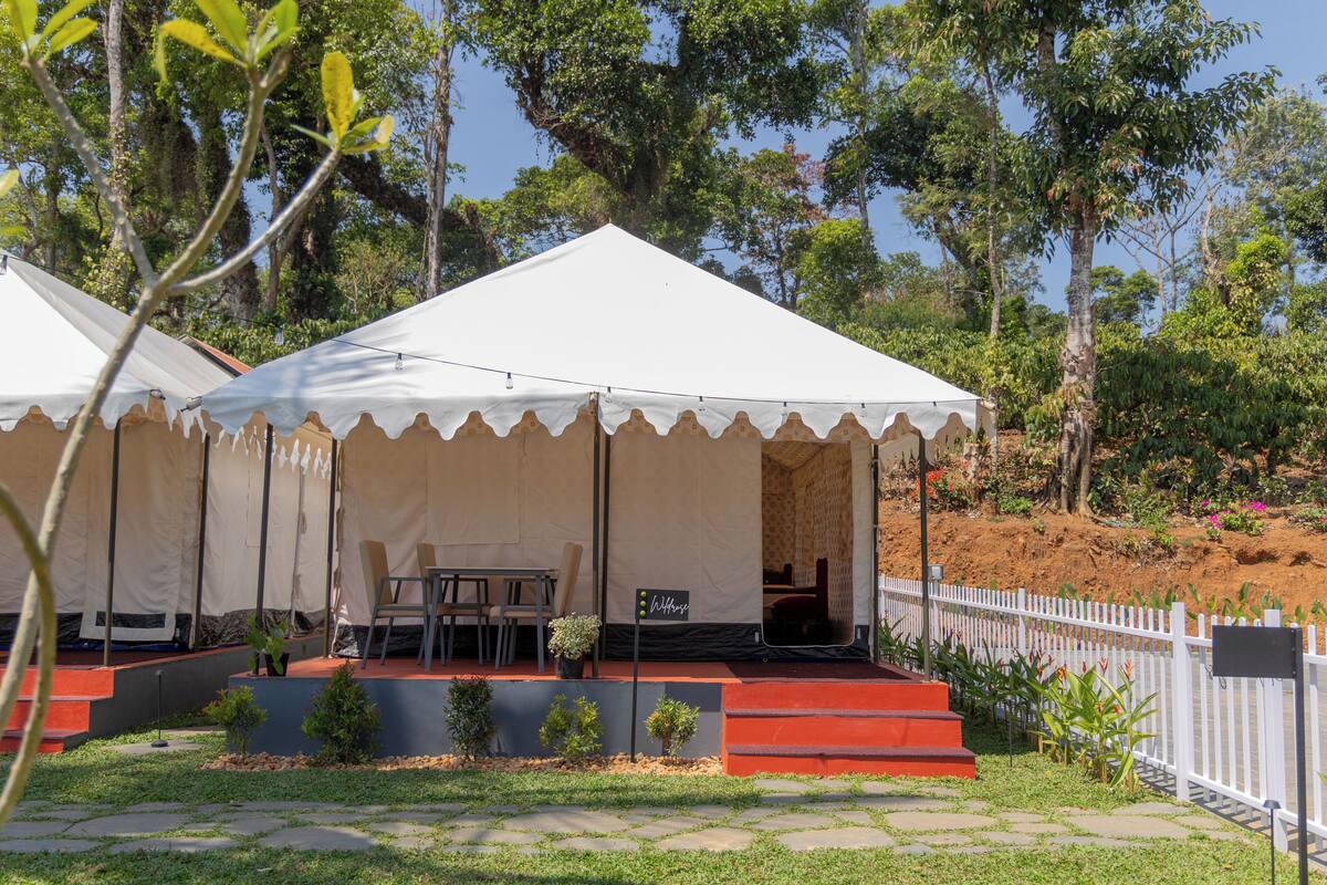 A tent with a stage, seating, and a small garden area.
