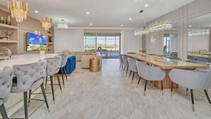 Una cucina moderna con una grande isola, posti a bar e un'area pranzo con un tavolo lungo.