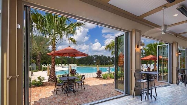 A spacious patio with a pool, outdoor seating, and a view of the surrounding landscape. - 5 Bed Multiple Bunks Perfect For Kids With Pool! 5 Bedroom Townhouse (Davenport)