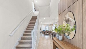 A staircase leading to a dining area with a wooden bench and potted plants. - Disney's Castle Mania Home! 7 Bedroom Villa (Clermont)